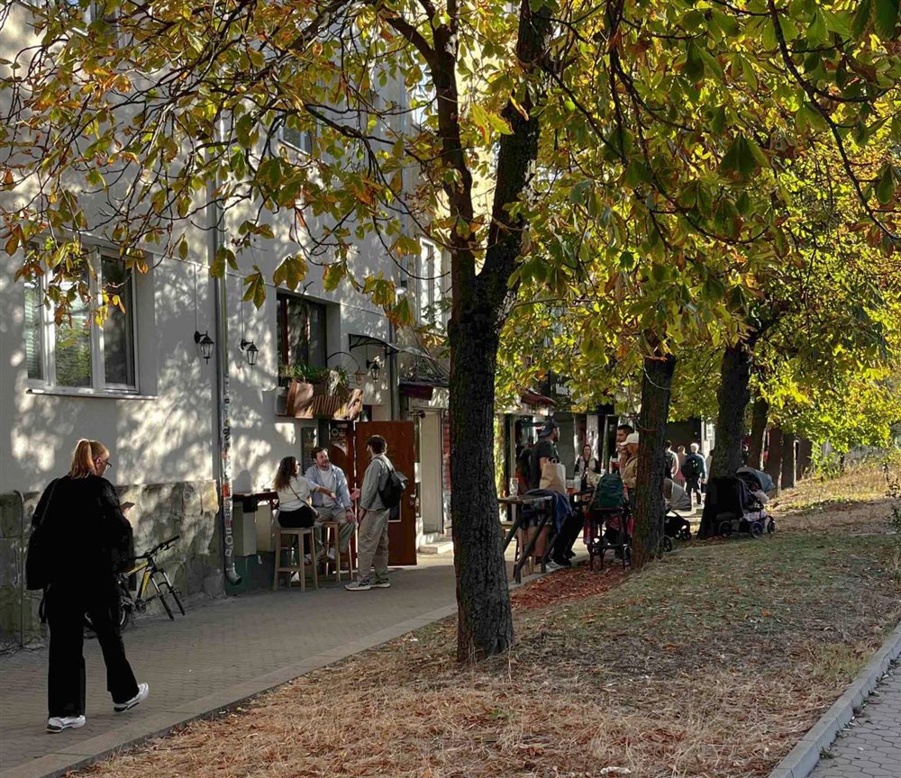 The street in front of Зимникъ today — guests at the tables under the chestnut trees